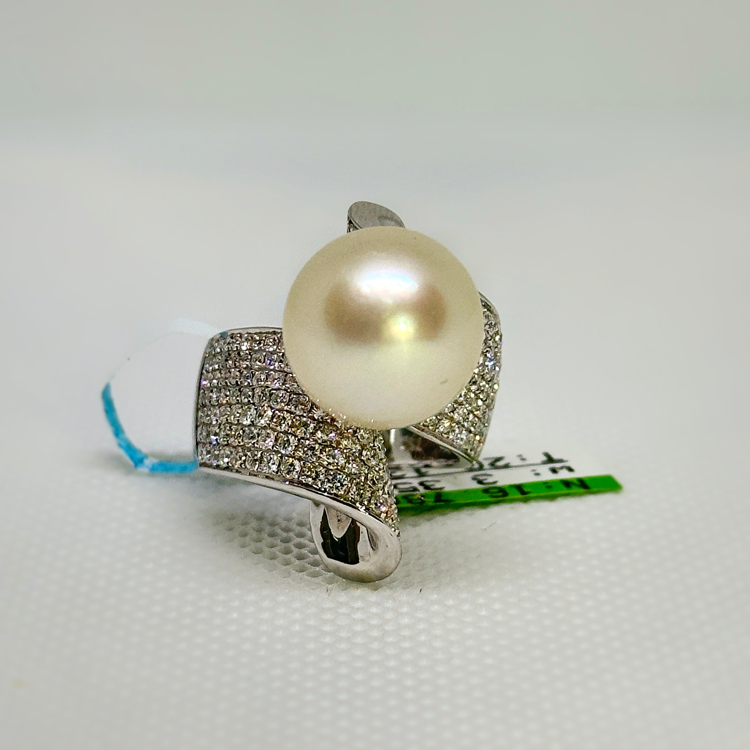 Pearl ring with silver band on a white background